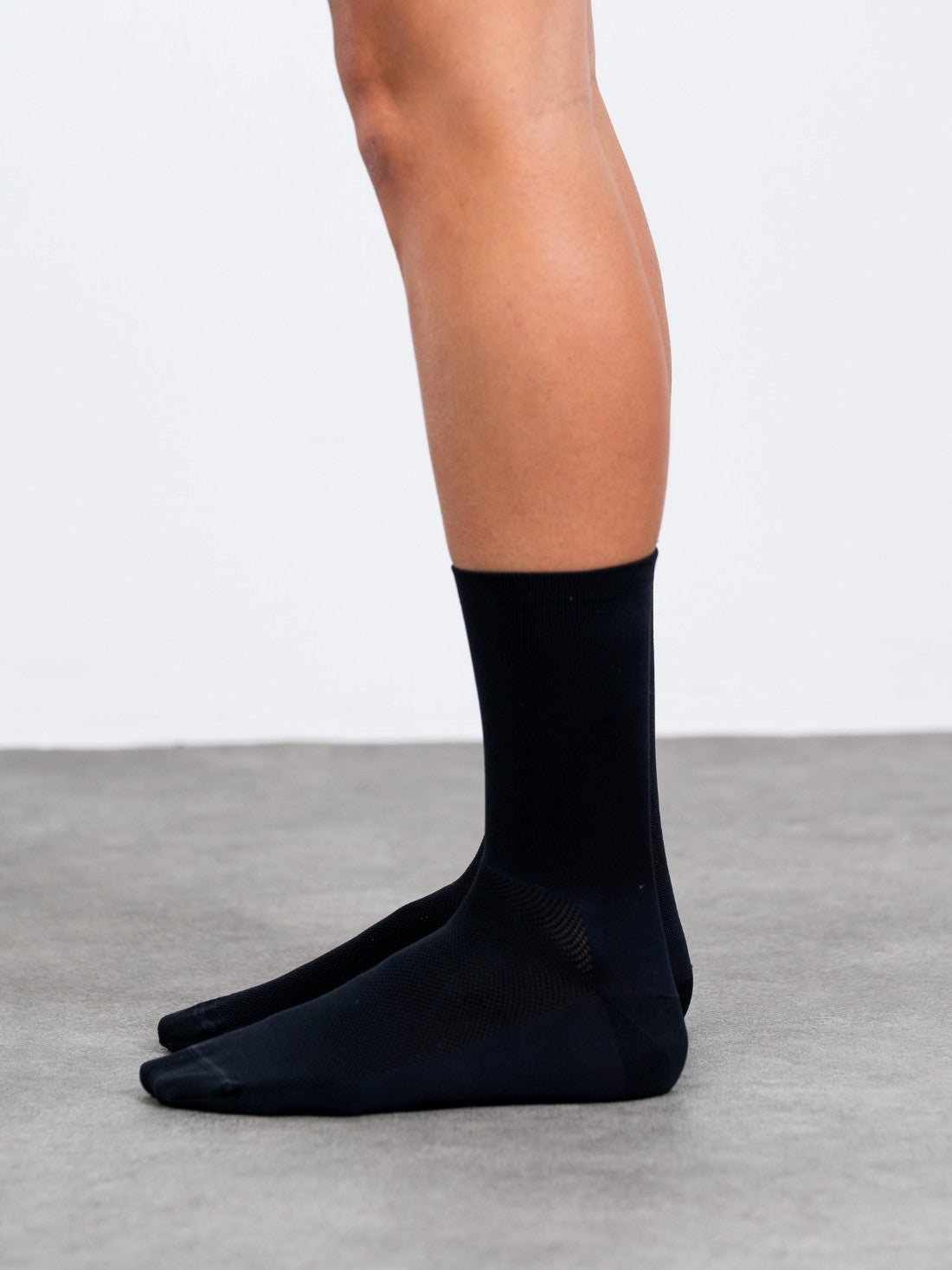 Plain black cycling socks with no logos. Minimalist unbranded design with high compression fit and 18cm cuff for a sleek stealth look.